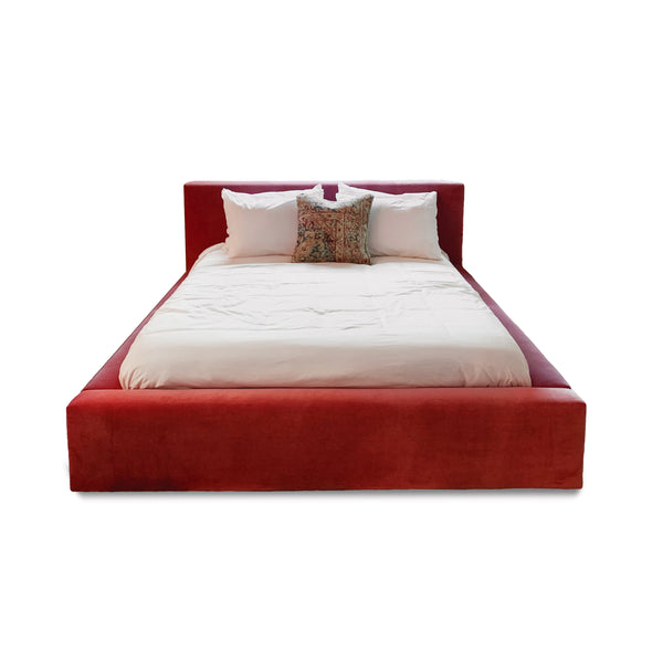 Custom velour upholstered queen bed with vintage pillows and modern silhouette