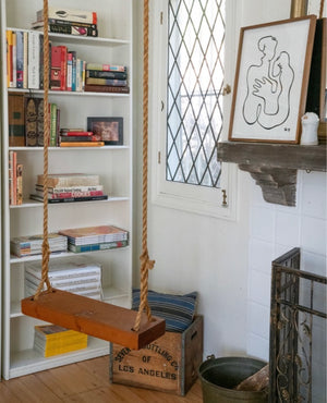 rope swing in house by bookshelf and fireplace in interior design space  by isabelle dahlin
