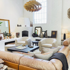 pair of dekor swivel chairs with vintage leather sofa and african art in atwater village vintage furniture store
