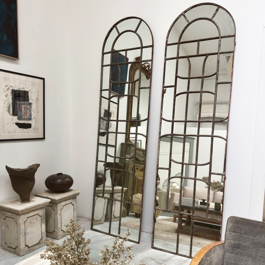 Tall arched wall mirrors with metal window paning. 