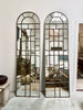 Tall arched wall mirrors with metal window paning. 