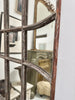 Tall arched wall mirrors with metal window paning. 