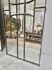 Tall arched wall mirrors with metal window paning. 