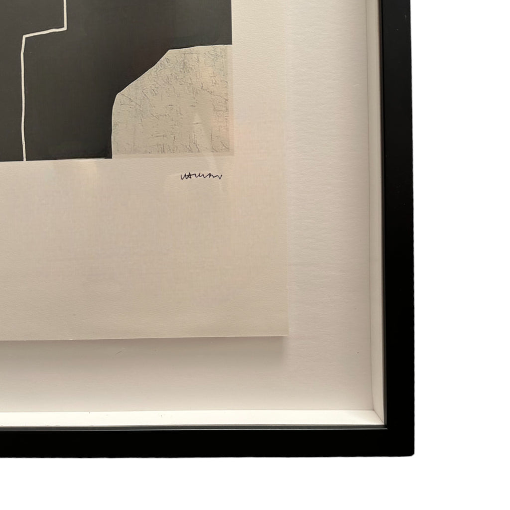 This piece is an abstract artwork by Eduardo Chillida, consisting of large black and white geometric shapes. The central area of the print features several irregular white rectangles arranged on a solid black background, giving the impression of overlapping forms. The design is minimalist, with sharp edges and contrasting tones that create a bold visual effect. It’s framed in a sleek black frame, adding a modern touch to the presentation.