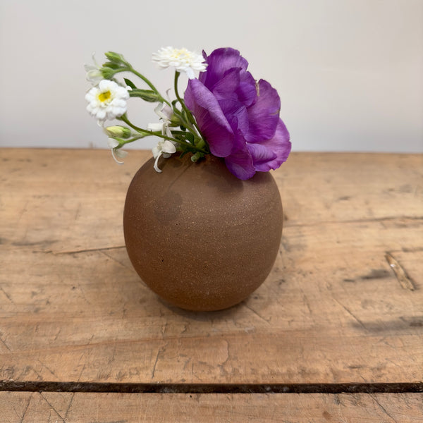 Sand colored bud vase with flowers
