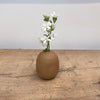 Mini sand colored ceramic bud vase shown with flowers