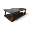 This coffee table has a solid, rectangular wooden base with a lower shelf for additional storage. The top is made of smooth, polished marble, which is cool to the touch and has a subtle sheen. The legs are carved with a simple, classic design, providing a sturdy and elegant support for the marble top. The overall look is a blend of traditional and modern elements, making it both functional and stylish.