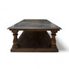 This coffee table has a solid, rectangular wooden base with a lower shelf for additional storage. The top is made of smooth, polished marble, which is cool to the touch and has a subtle sheen. The legs are carved with a simple, classic design, providing a sturdy and elegant support for the marble top. The overall look is a blend of traditional and modern elements, making it both functional and stylish.