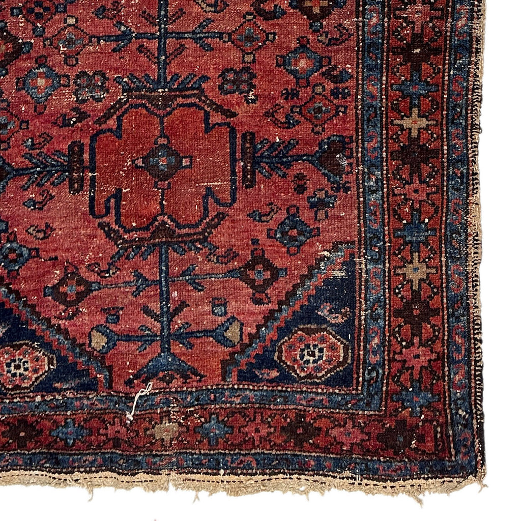 Vintage handmade Persian accent rug with deep red background and blue accents. 