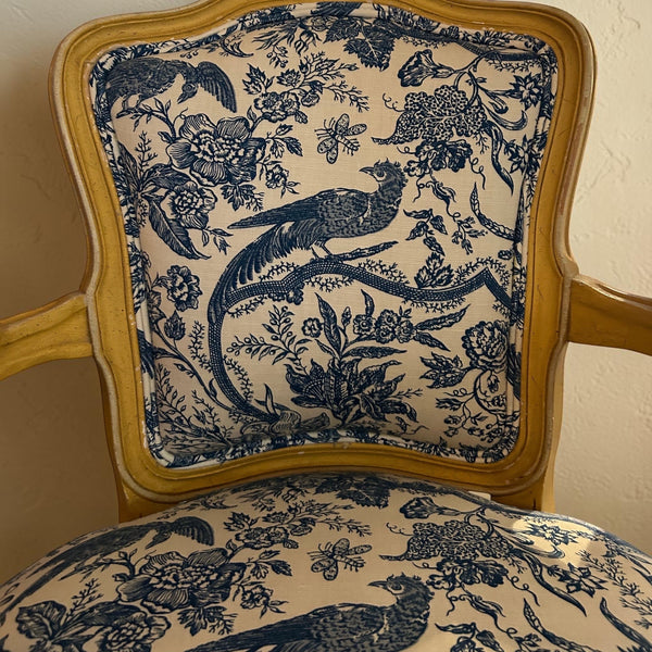 deKor vintage chair featuring a light wood frame and blue and white toile fabric with intricate bird and floral motifs