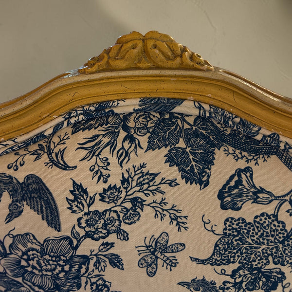 deKor vintage chair featuring a light wood frame with carved details and blue and white floral toile fabric upholstery