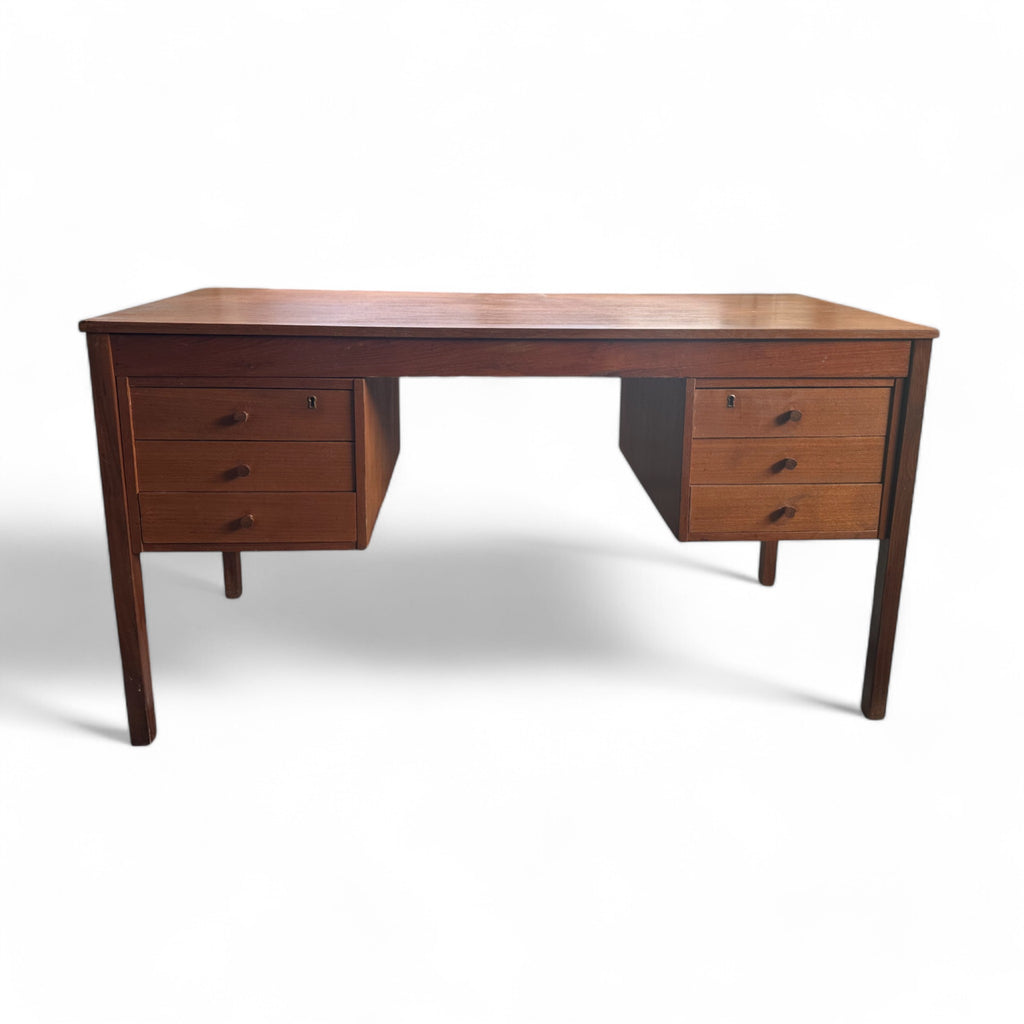 This vintage mid-century desk has a simple, rectangular design with a warm wood finish. It features two sets of drawers on each side, each with three drawers and small wooden pulls. 