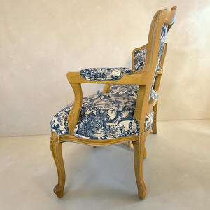 deKor vintage blue and white toile patterned armchairs with light wood frames on a black and white checkered floor