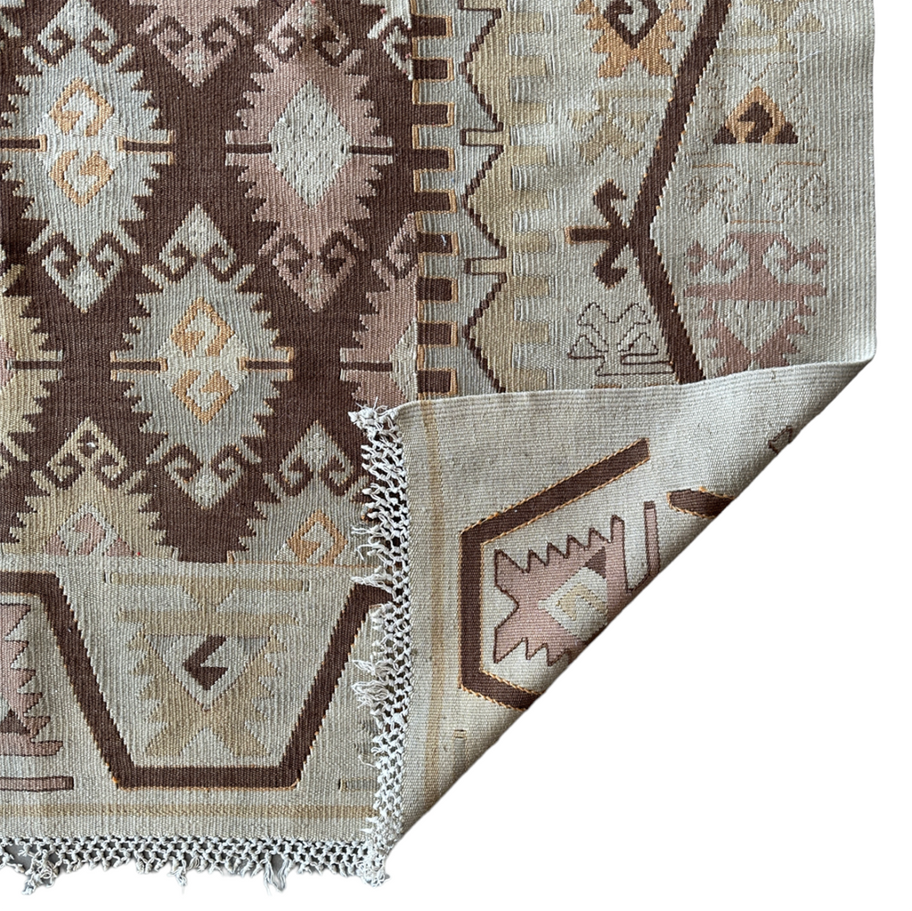 flatweave area rug with brown, pink and yellow designs on beige background