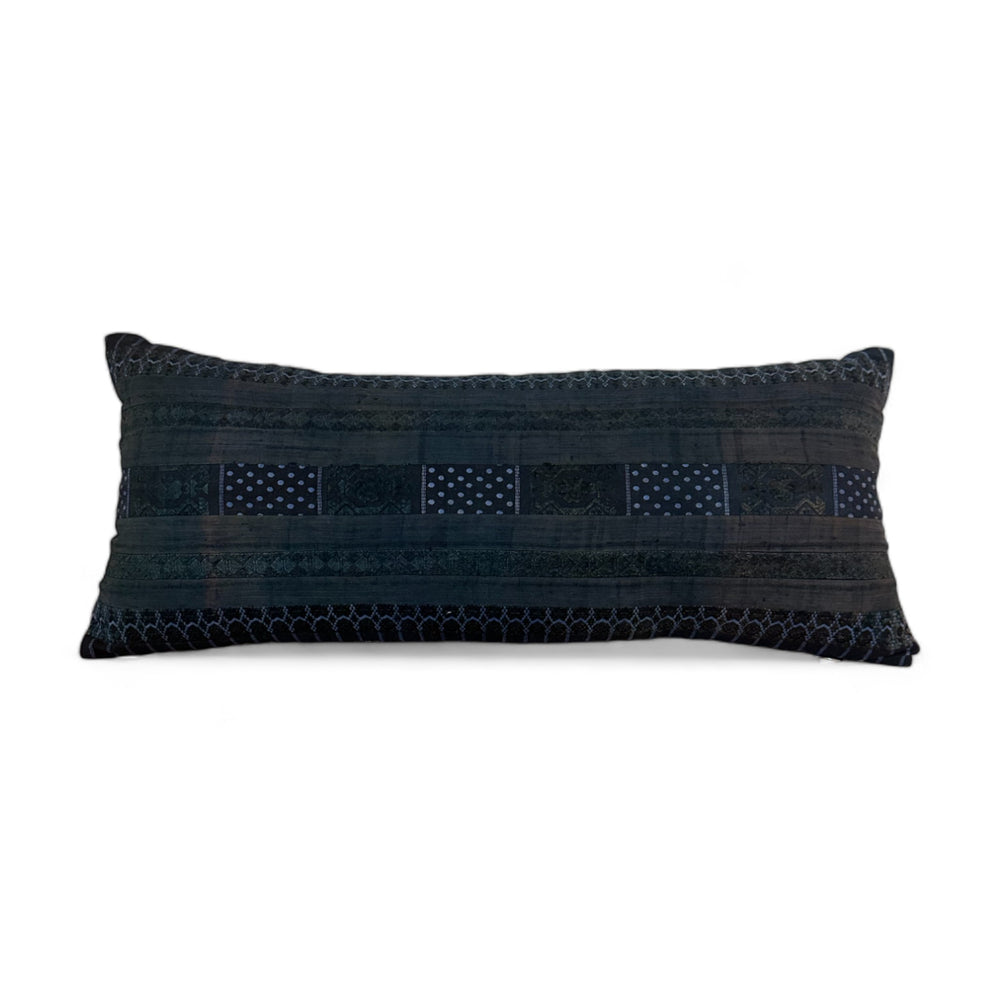 Vintage bolster pillow in shades of blue with different patterns. 