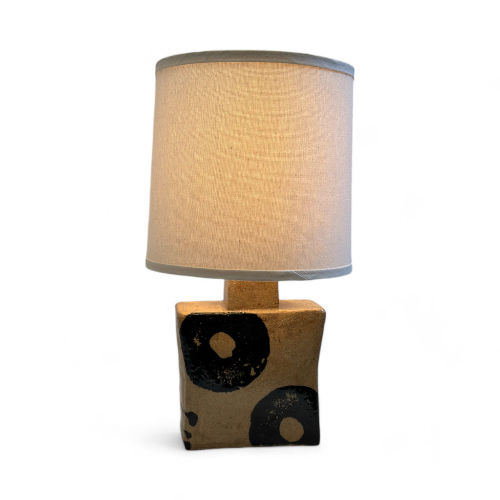 One-of-a-kind Nishi ceramic lamp by Japanese ceramist Koichi Nishi, a celebrated LA local artist. This unique lamp features a tan square base with black painted circular accents blending traditional craftsmanship with modern design. Perfect for adding a touch of artisanal charm to any space.