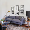 custom midcentury linen sofa pin legs framed art and vintage home decor