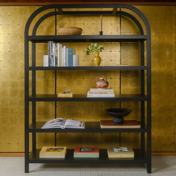 deKor arched frame large bookcase in black oak veneer with five shelves against a gold leaf wall