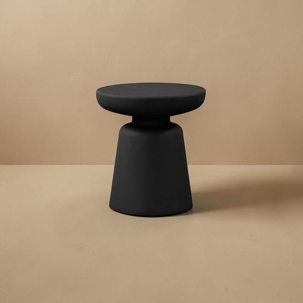 deKor compact black polypropylene outdoor side table with a minimalist pedestal design against a beige background.