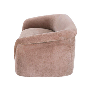 deKor blush velvet-like rolled arm sofa with a curved silhouette and plush foam cushioning, side view.