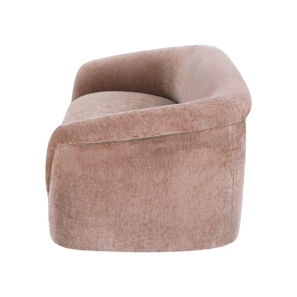 deKor blush velvet-like rolled arm sofa with a curved silhouette and plush foam cushioning, side view.