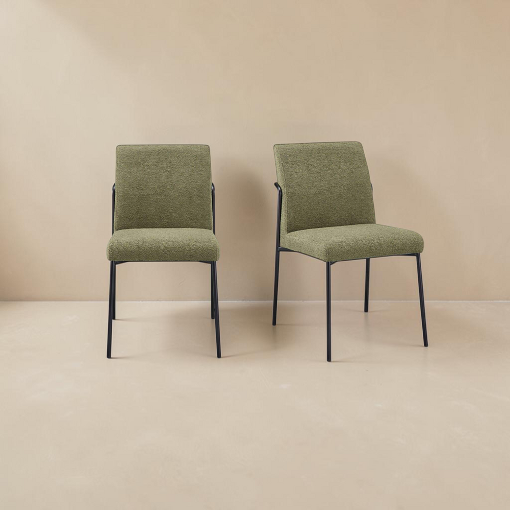Set of two deKor dining chairs with green upholstered seats and minimalist black curved iron frames.