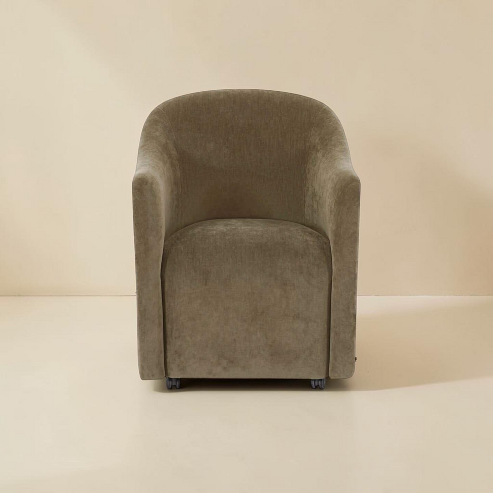 deKor green textured polyester rolling barrel dining chair with a curved back and comfortable foam padded seat.