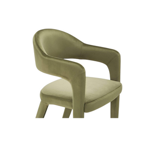 deKor barrel back dining chair upholstered in soft green velvet with a continuous curved frame and armrests