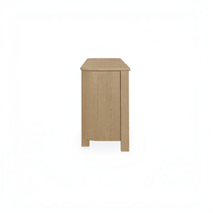 deKor natural oak sideboard featuring a modern curved corner design and solid wood legs, side view.