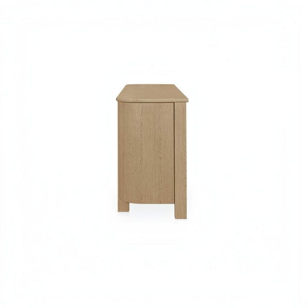 deKor natural oak sideboard featuring a modern curved corner design and solid wood legs, side view.