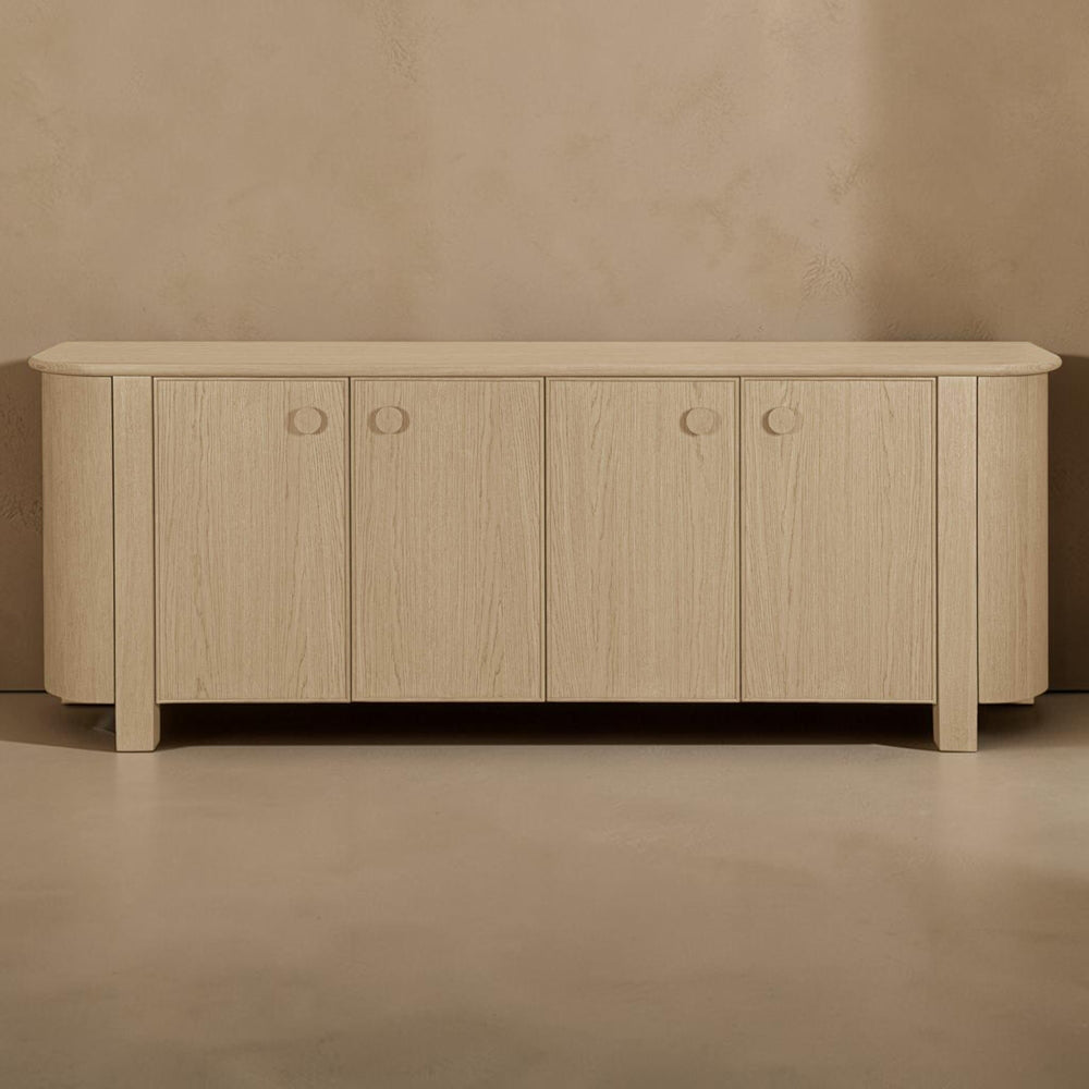deKor natural oak veneer sideboard with four doors, curved corners, and minimalist circular handles.