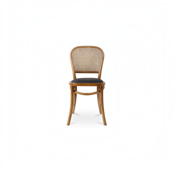 deKor rattan dining chair with a natural wood frame, woven cane backrest, and a dark black polyurethane seat.