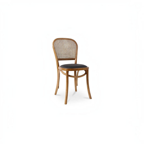 deKor rattan dining chair with a natural wood frame, woven cane backrest, and a dark polyurethane seat cushion.
