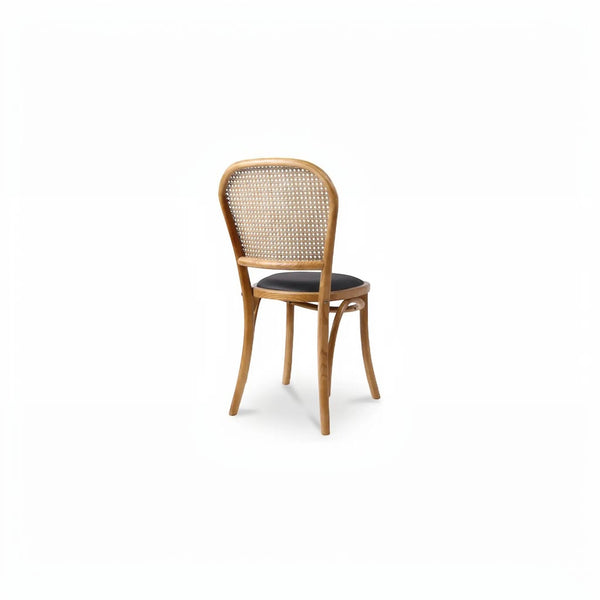 deKor rattan dining chair with a natural wood frame, woven backrest, and a dark polyurethane seat, rear view.