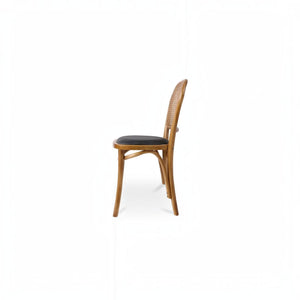 deKor rattan dining chair with a natural wood frame and dark polyurethane seat in a side profile view