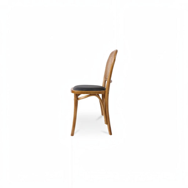deKor rattan dining chair with a natural wood frame and dark polyurethane seat in a side profile view
