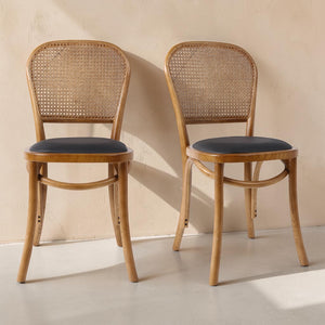 deKor set of two bohemian rattan dining chairs with natural wood frames and dark polyurethane padded seats