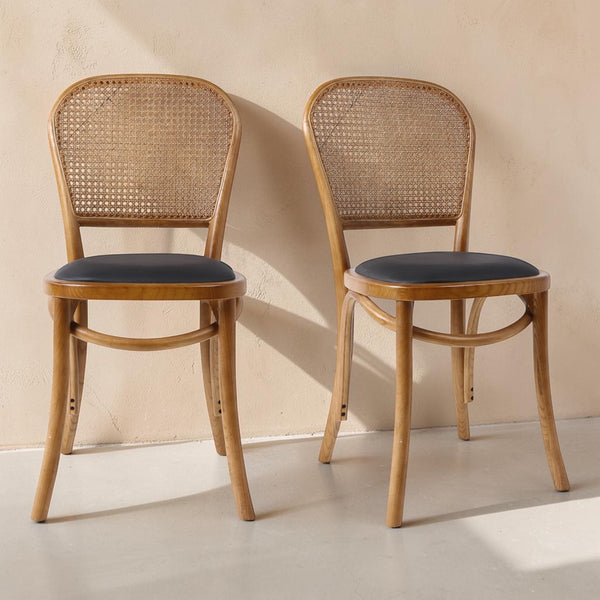 deKor set of two bohemian rattan dining chairs with natural wood frames and dark polyurethane padded seats