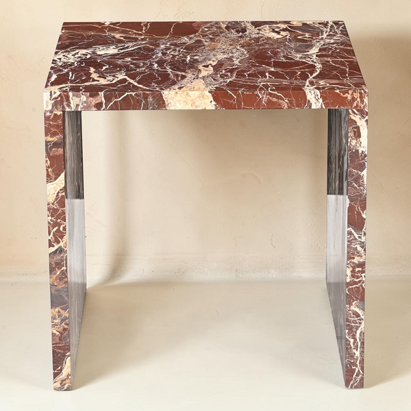 deKor Rosso Levanto marble accent table featuring a bold waterfall design with vibrant red stone and gold veining.