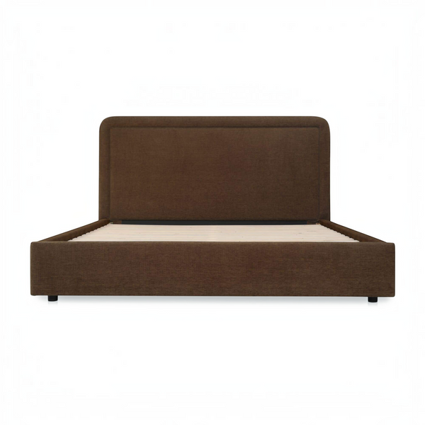 deKor Simon storage bed in brown fabric with a rounded headboard and piped detailing, front view.