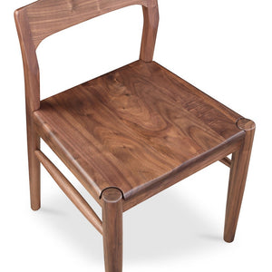 deKor solid walnut dining chair with a curved open-back design and mid-century modern silhouette in walnut brown.