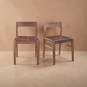 deKor set of two solid walnut dining chairs featuring a mid-century modern curved open-back design in walnut brown.