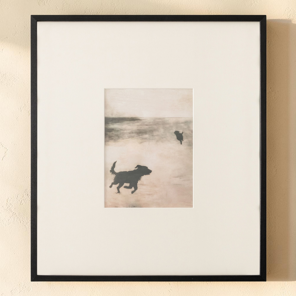 deKor Strand 2 framed print featuring silhouettes of dogs on a misty beach with earthy tones and a black wood frame