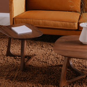 deKor walnut end table with a midcentury modern design, featuring a smooth wooden surface on a textured brown rug.