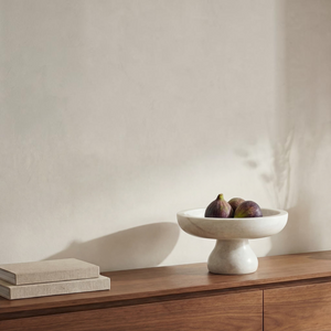 deKor white Rajnagar marble pedestal bowl holding fresh figs on a wooden console table with stacked books