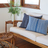 warm wood sofa with white upholstery and vintage fabric pillows