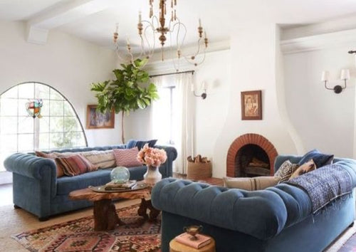 Two custom made chesterfield sofas with a live edge coffee table and vintage chandelier