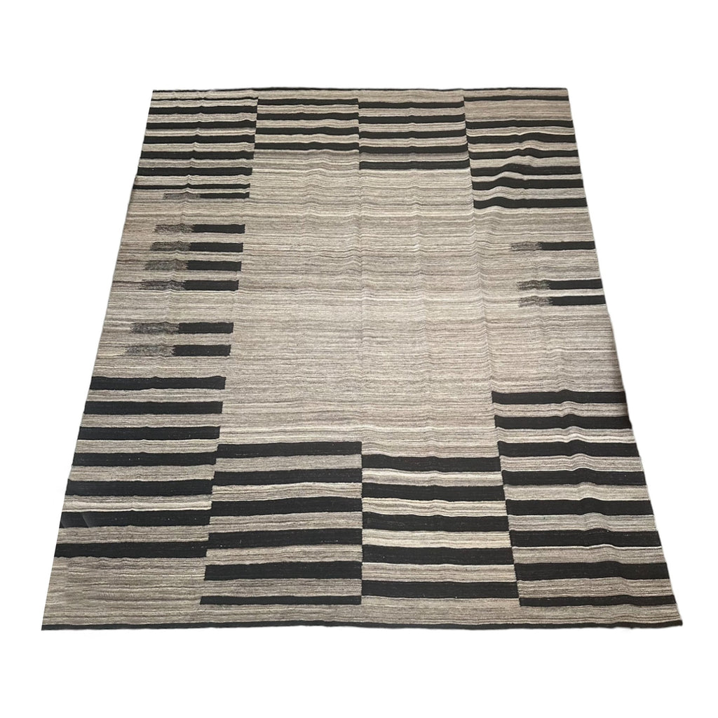 Beige & brown handwoven kilim rug with black stripes in certain areas.