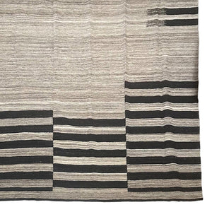 Beige & brown handwoven kilim rug with black stripes in certain areas.