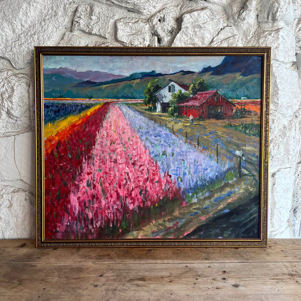 Colorful painting of flower farm by R.E. Riwell framed art on white wall. 